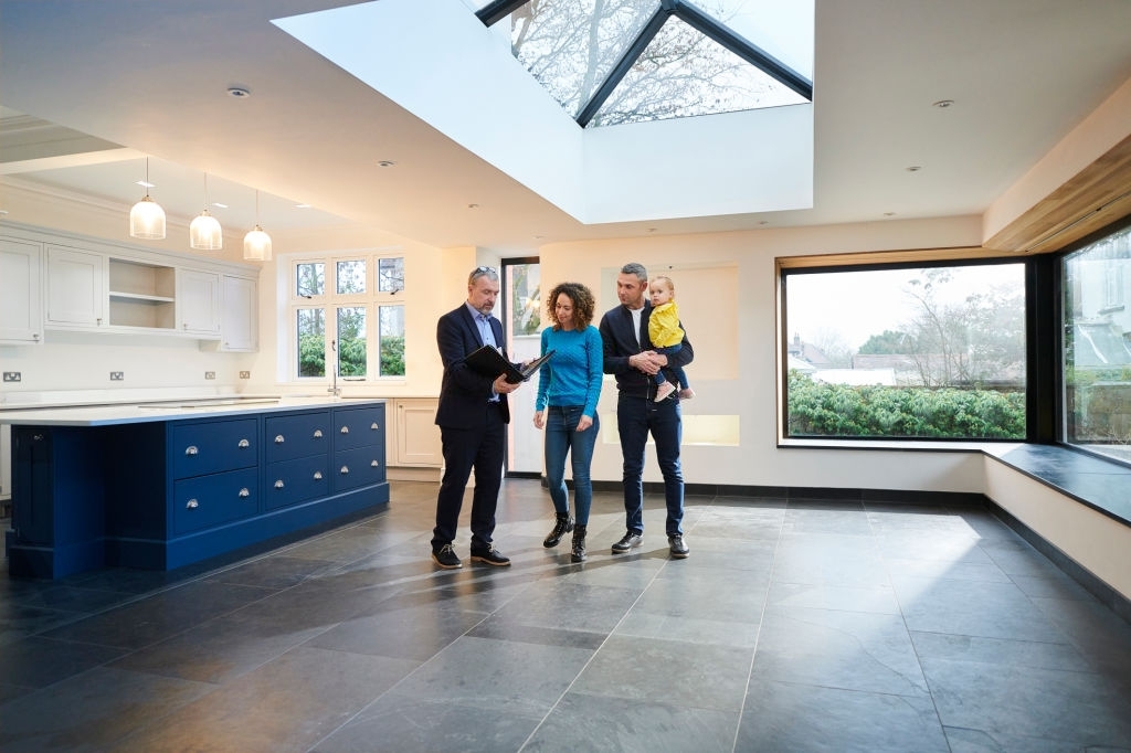 young family looking round new house with estate agent